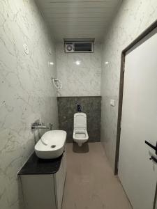 a small bathroom with a toilet and a sink at Hotel Pragya Paradise in Indore
