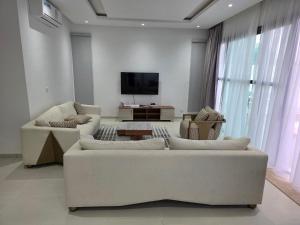 un soggiorno con due divani e una TV a schermo piatto di Villas Maciral Assinie a Assinie