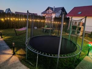 Un patio trasero con un trampolín en el patio por la noche. en Vila Decebal, en Râșnov