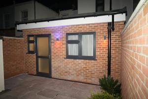 un edificio de ladrillo con puerta y ventana en Luxury Rooms Near Heathrow, en Cranford