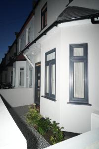 un edificio blanco con dos ventanas y una puerta en Luxury Rooms Near Heathrow, en Cranford