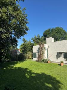 een tuin met een wit gebouw en bomen bij Casa quinta ideal para descansar in General Rodríguez