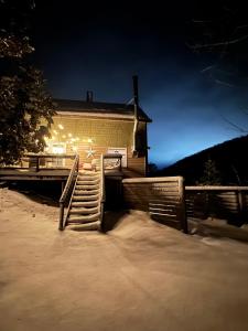 a house with stairs in the snow at night at Maples Retreat - 2 Acres - Fireplace in Ellicottville