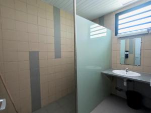 a bathroom with a sink and a shower at Auberge de Poé in Bourail