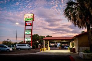 Una gasolinera con un letrero de concesionario de automóviles en Family Garden Inn & Suites, en Laredo