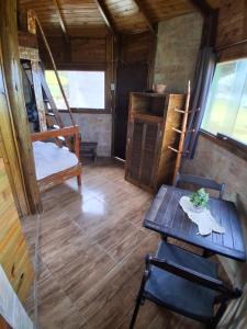 ein Zimmer mit einem Tisch und Stühlen in einer Hütte in der Unterkunft Bangalô Pé na Areia in Imbituba
