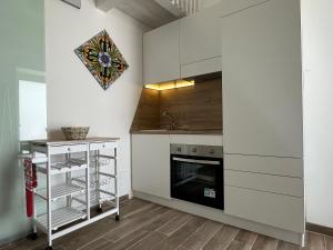 a kitchen with white cabinets and a fireplace at Pietre al Sole di Sicilia in Modica