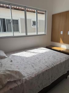 巴纳伊巴Casa em Parnaíba的卧室里有一张床，窗户很大