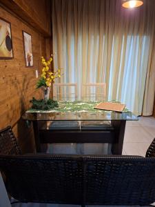 un tavolo con sedie e un vaso di fiori sopra di Casa reformada com Ar condicionado e Garagem, perto CMPC e BR 116 com Self Check-in a Guaíba