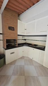 a kitchen with white cabinets and a tile floor at Suites Novas in Cabo Frio +17 photos
