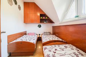 deux lits dans une petite pièce avec une fenêtre dans l'établissement Casa Termalis in Terme Čatež, à Brežice