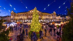 um grupo de pessoas em volta de uma árvore de Natal em frente a um prédio em Galanthus em Aosta