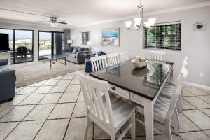 una sala da pranzo e un soggiorno con tavolo e sedie di Surf Dweller 112 Large gulf front condo a Fort Walton Beach