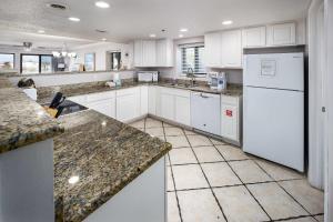 una cucina con elettrodomestici bianchi e ripiani in granito di Surf Dweller 112 Large gulf front condo a Fort Walton Beach