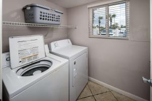 una lavanderia con lavatrice e finestra di Surf Dweller 112 Large gulf front condo a Fort Walton Beach Altre 31 foto