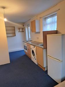 eine Küche mit einem Kühlschrank, einer Waschmaschine und einem Trockner in der Unterkunft Charming Garden Guest House in Hayes & Harlington in Hayes + 21 Fotos