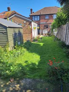 ein Hinterhof mit einem Garten, einem Haus und einem Zaun in der Unterkunft Charming Garden Guest House in Hayes & Harlington in Hayes