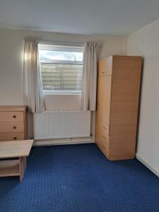 Zimmer mit einem Fenster, einem Bett und einem Schreibtisch in der Unterkunft Charming Garden Guest House in Hayes & Harlington in Hayes