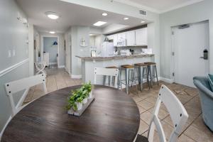 una cucina e un soggiorno con tavolo e sedie in legno di Waters Edge 102 Large 1st floor condo a Fort Walton Beach
