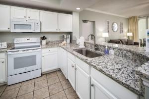 una cucina con mobili bianchi e un lavandino di Waters Edge 102 Large 1st floor condo a Fort Walton Beach