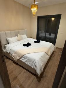 マルティルにあるAppartement haut standing 2 chambres piscine Martilのベッドルーム1室(大型ベッド1台、黒い靴2本付)