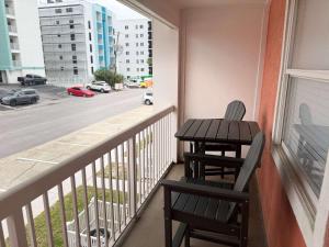 a table and chairs on a balcony with a view of a street at Tropical Isle 209 w Convenient Beach Access in Fort Walton Beach