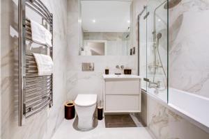 ein weißes Badezimmer mit Toilette und Dusche in der Unterkunft Amity Moonbirds by Artsy in Raynes Park