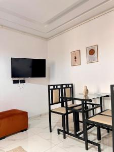 a living room with a table and chairs and a tv at Palmier d'or in Tunis