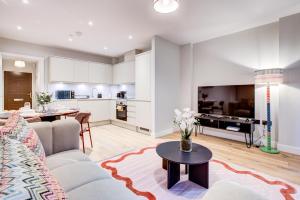 ein Wohnzimmer mit Sofa und Tisch in der Unterkunft Amity Moonbirds by Artsy in Raynes Park