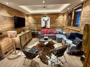 ein Wohnzimmer mit Sofa und Fernseher in der Unterkunft Le Refuge d'Ours, Champagny in Champagny-en-Vanoise