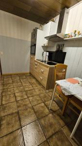 een keuken met een tegelvloer met een tafel en een fornuis bij Apartment Wildgrund in Siegen