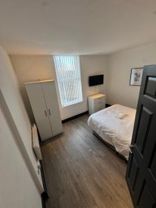 ein Schlafzimmer mit einem Bett, einer Kommode und einem Fenster in der Unterkunft The residency appartment's in Litherland