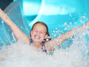 une jeune fille est sur un toboggan aquatique dans l'établissement 4 star holiday home in Henne, à Henne