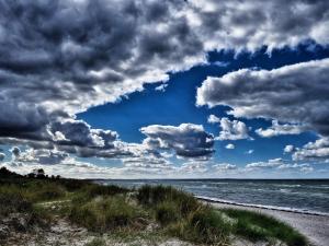 Una playa con cielo nublado y el océano. en 14 person holiday home in Glesborg, en Glesborg