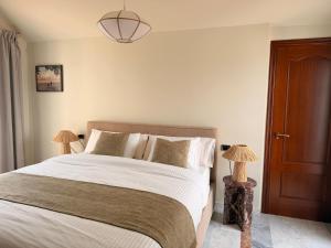 een slaapkamer met een groot bed en een bruine deur bij CASABA - Boutique - Torre del Mar in Torre del Mar