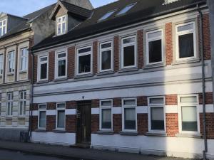 a white building with windows on a city street at Apartment in the heart of Esbjerg Center in Esbjerg
