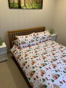 Skye Lodge في تينابرويك: سرير مع لحاف ووسائد بيضاء عليه