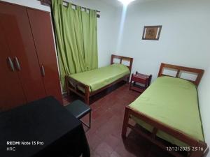a small room with two beds and a table and a table at Kilometro Cero in La Quiaca