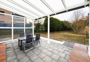 een pergola op een patio met een tafel en stoelen bij Haupthaus in Troisdorf