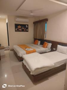 a hotel room with two beds and a window at Hotel VR Villa in Vadodara +15 photos