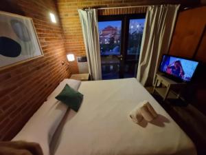 a hotel room with a bed and a television at Club carilo playa Edificio del bosque in Carilo