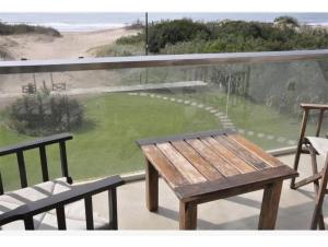 a wooden bench sitting on top of a balcony at Club carilo playa Edificio del bosque in Carilo