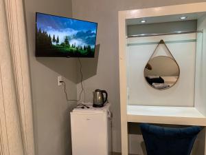 een badkamer met een spiegel en een kleine koelkast bij 101-Quarto Pousada Hg in Vila Nova do Sul