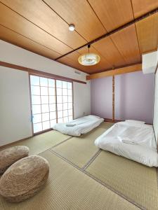 due letti in una stanza con due finestre di furano lavender house a Furano