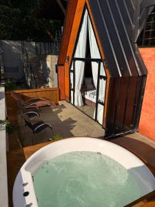 uma pequena casa com uma banheira no quintal em Chales da Trilha em Penha