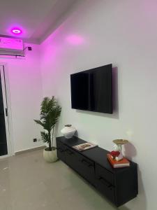 a living room with a tv on a white wall at Serenity by Feliho House in Dakar