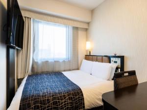 a hotel room with a bed and a window at APA Hotel Namba Ekihigashi in Osaka