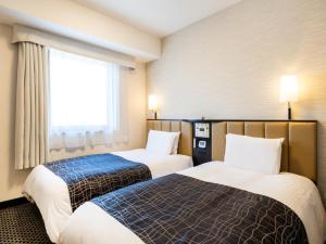 a hotel room with two beds and a window at APA Hotel Namba Ekihigashi in Osaka