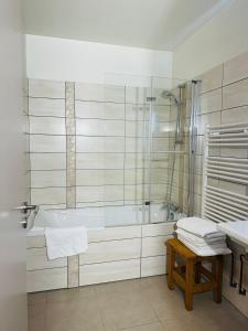 Hôtel privatisé & spa - séjour all inclusive -Adults only في Rupt-sur-Moselle: حمام أبيض مع حوض استحمام ومغسلة