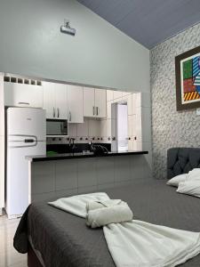 a kitchen with white cabinets and a bed in a room at Residencial Flat Debora in Florianópolis